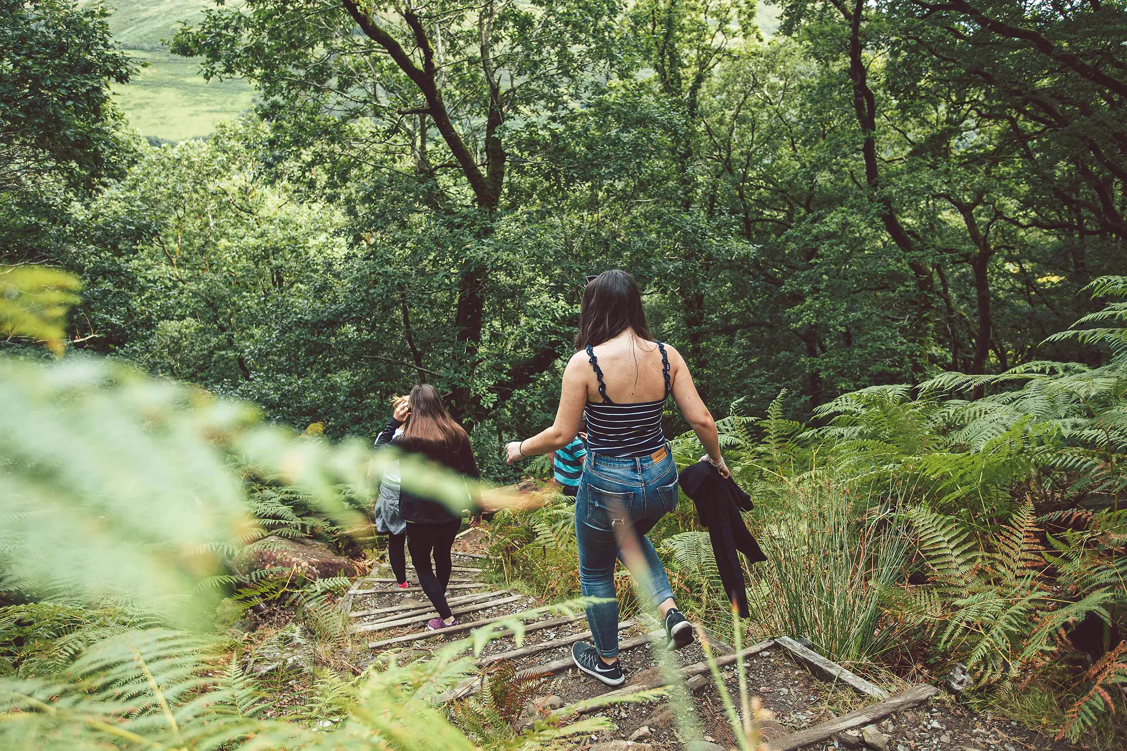 Two women walking a forest trail